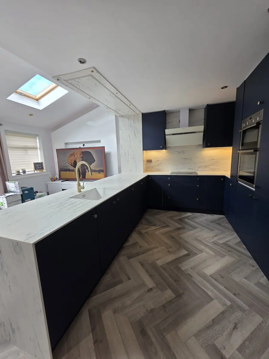 Navy handleless kitchen with a herringbone floor