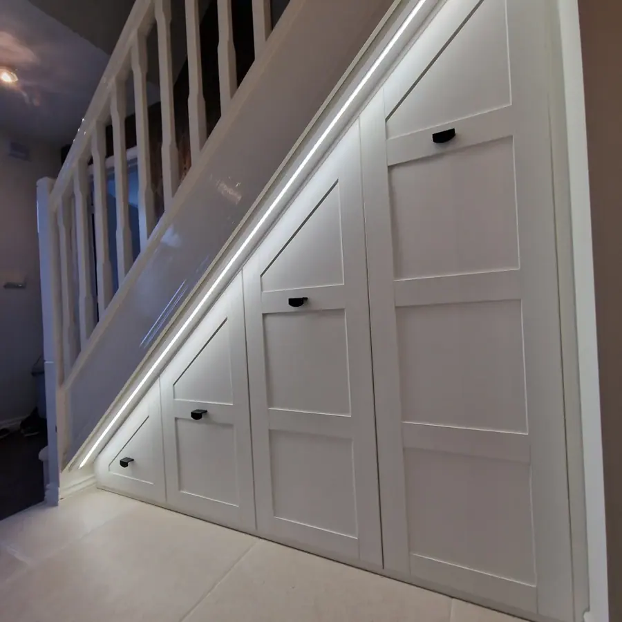 Shaker doors under the stairs with black handles