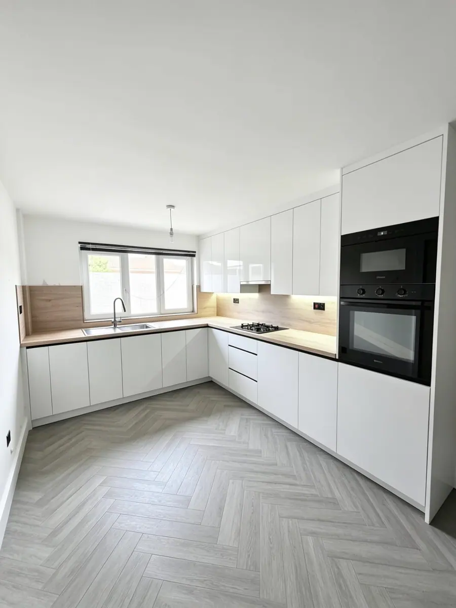 White handleless kitchen with a herringbone floor